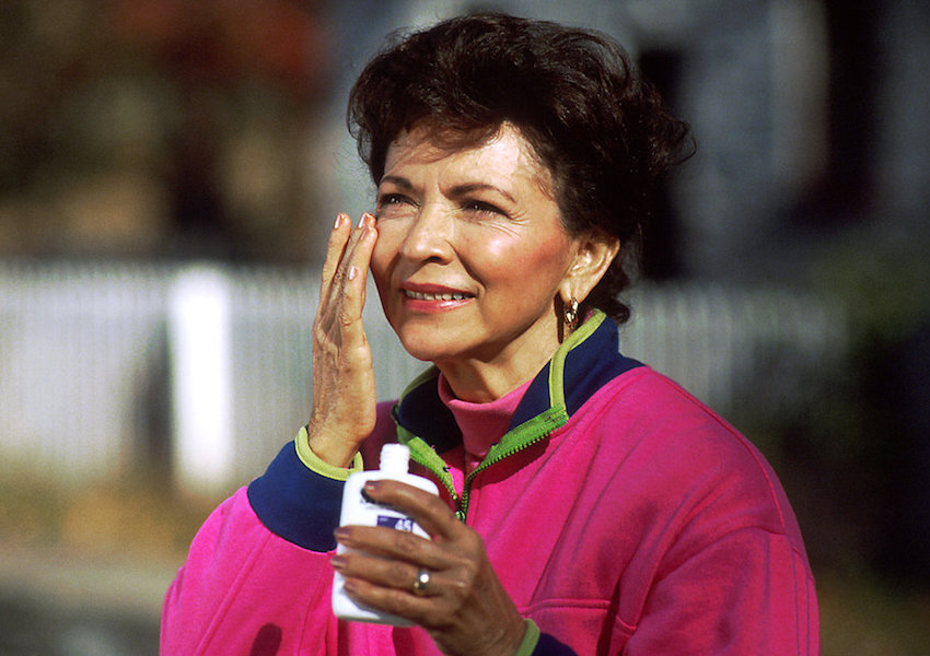 woman applying sunscreen to her face