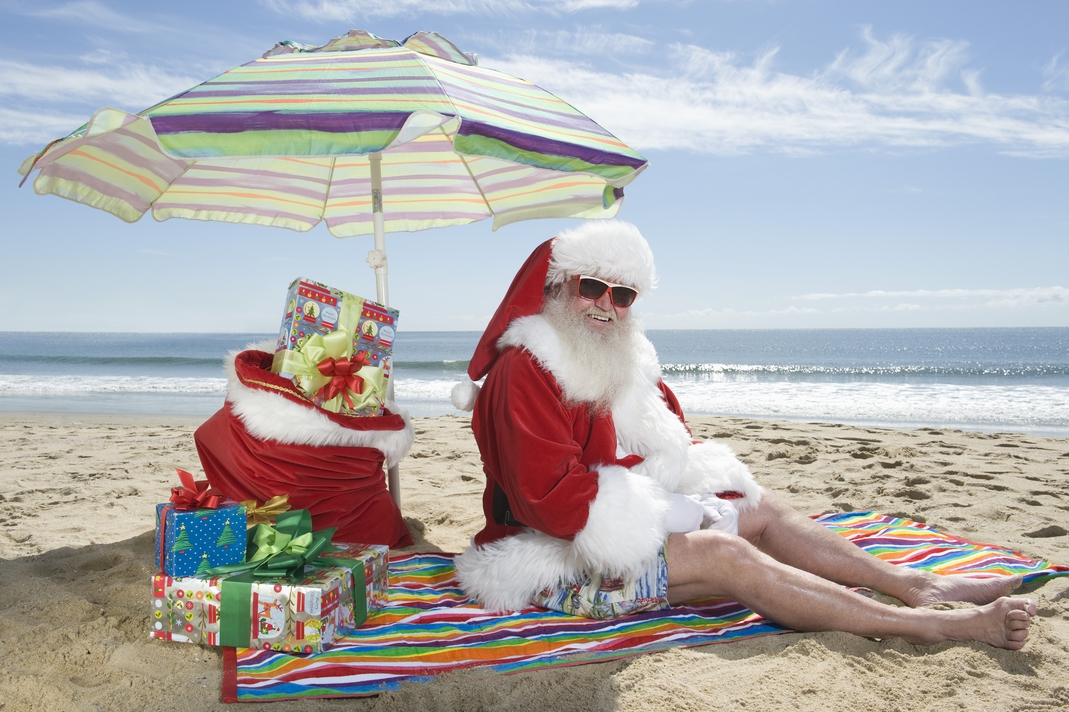 Santa-clause sitting on a beach smiling