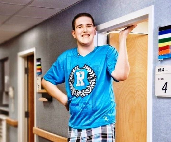 Broc posed next to a doorway, towering over it 