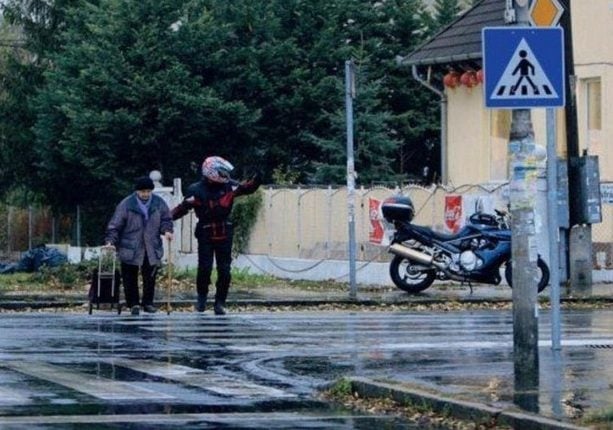 man helps old lady cross the street